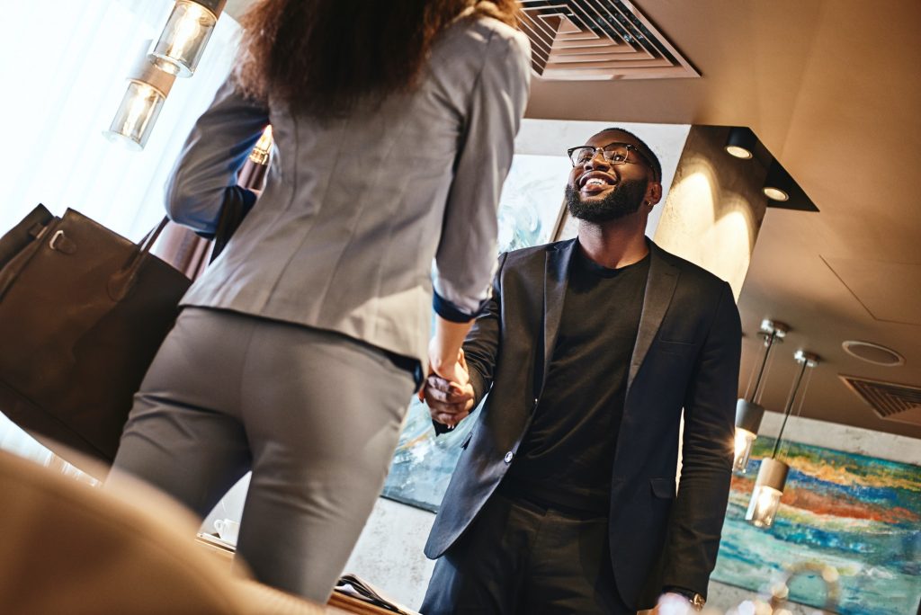 Team work makes the dream work. Excited businessman and businesswoman are shaking hands. Business